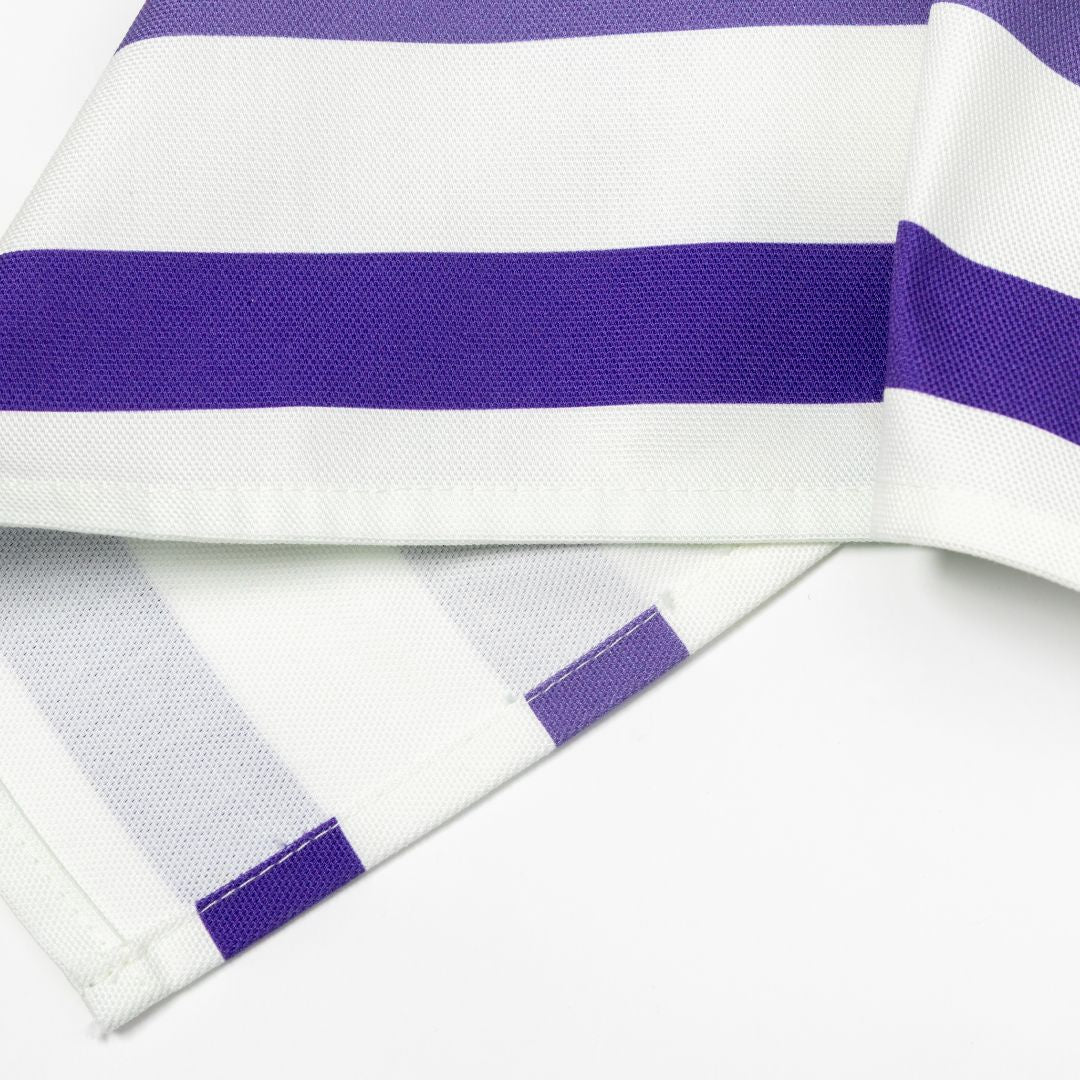 Close-up of a folded tea towel with wide rainbow stripe design on a white background