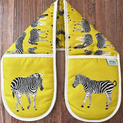 Yellow Zebra illustrated organic cotton oven gloves on wooden surface