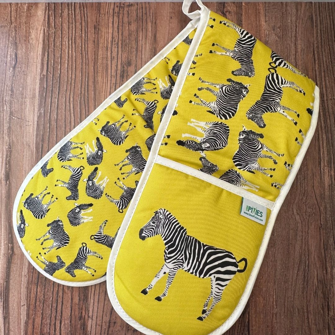 Yellow Zebra illustrated organic cotton oven gloves on wooden surface