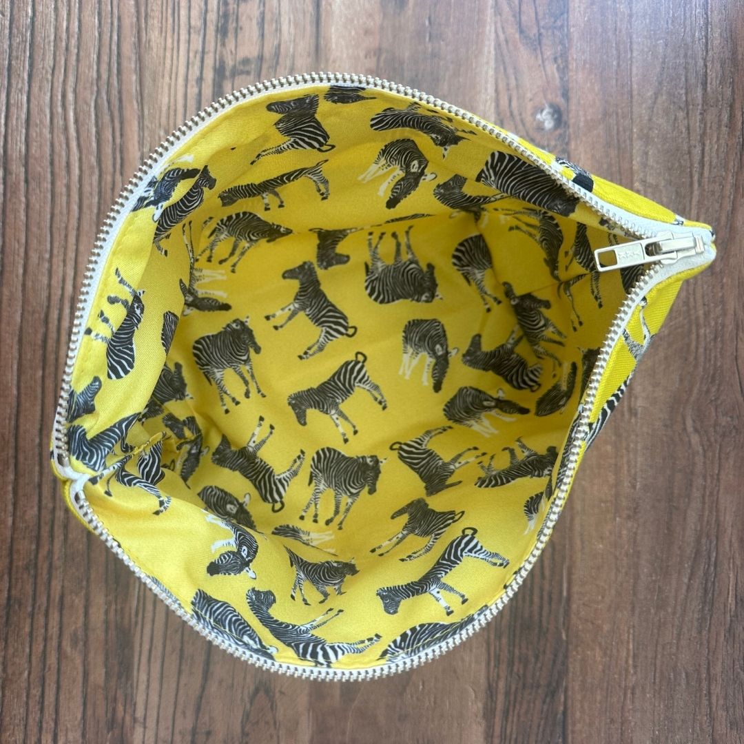 Bright yellow Zebra illustrated really useful bag shown  from above open with waterproof printed lining visible