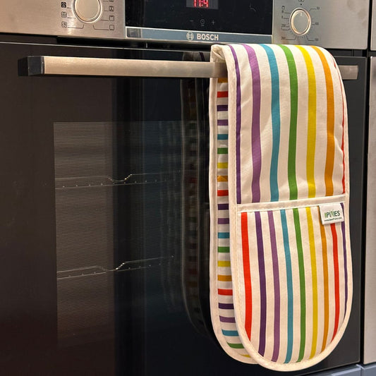 A striped oven mitt hanging from a stainless steel handle on a built-in Bosch oven. The mitt has vertical rainbow-coloured stripes on a white background