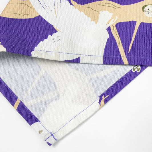 Close-up of the edge of a purple British Owl tea towel  shown on a plain white counter