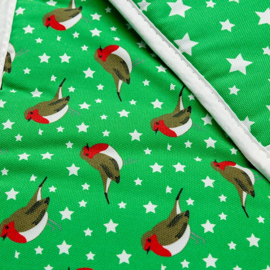 Close up details of binding edge on a pair of bright green organic cotton oven mitts with  fun illustrative design of red robin birds and star