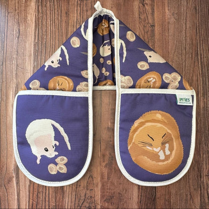 Rich Purple Hazel Dormouse design organic cotton Oven Mitts shown on a wooden counter