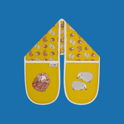 Sunny yellow Hedgehog design organic cotton oven mitts, shown here on a plain blue background