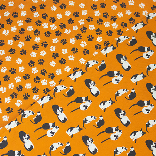 orange cats and paw prints tea towels shown side by side