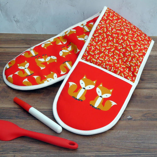 Red Fox Oven Gloves in Organic Cotton shown on a wooden surface