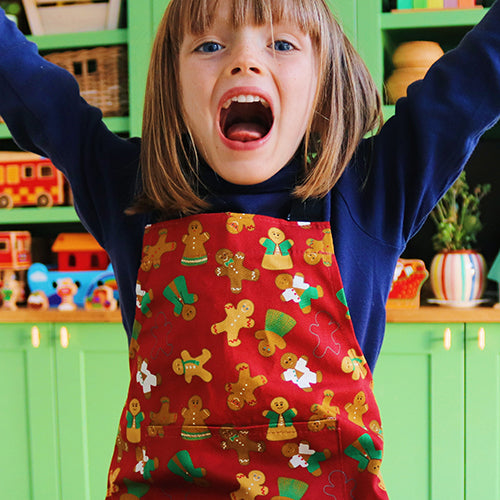 Gingerbread Design Organic Cotton Apron model wears younger child size