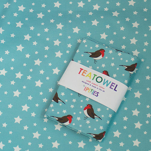 Robins tea towel shown in recyclable packaging laid on and Robin and Stars coordinating tea towel design