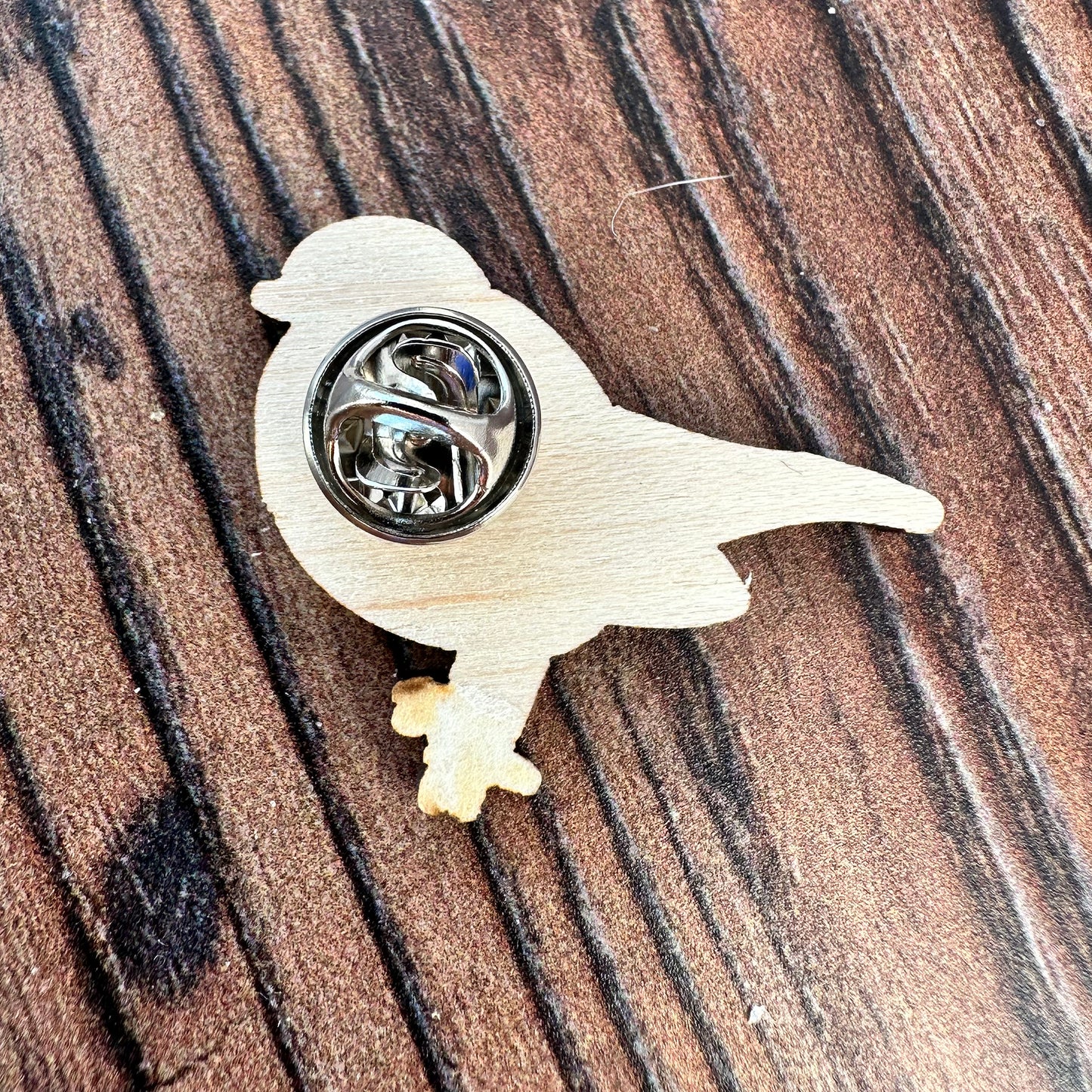reverse of the wooden robin pin badge