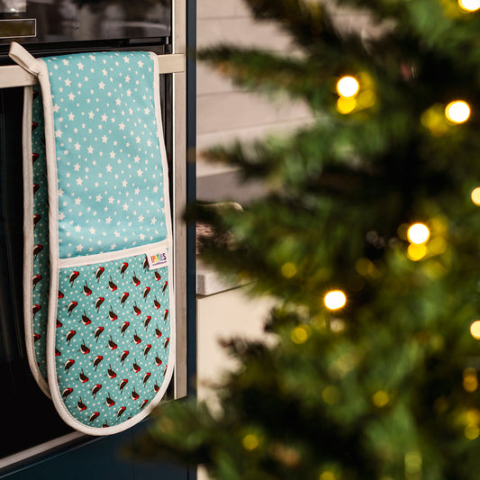 Blue Robins Oven Gloves in 100% Organic Cotton shown hanging on oven door