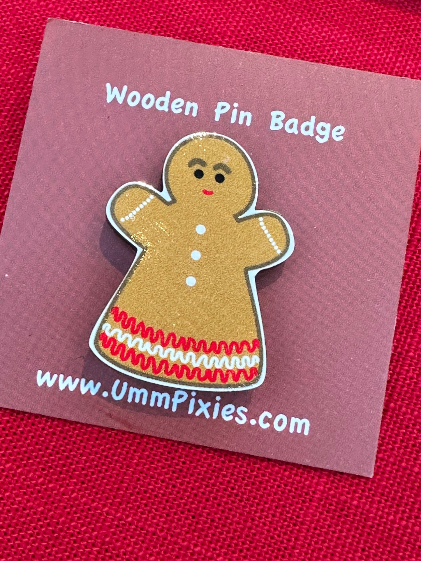 Wooden Gingerbread pin badge shown on backing card